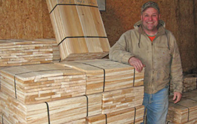 Steve Boyer stands next to ready-to-ship bundles of shingles from the Trenary Wood Products business he owns with his wife, Sharon. Visit trenarywoodproducts.com to see more products, or contact them by e-mail at holmquist@tds.net or call 906-446-3326.