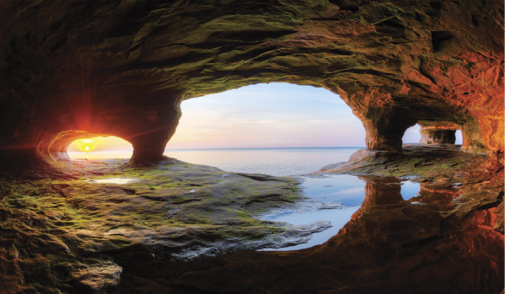Lake Superior sea caves—This is one of the photographer's favorites because of the arch portals' composition and reflection in the foreground. The sun only sets through the left portal a few days in the year.