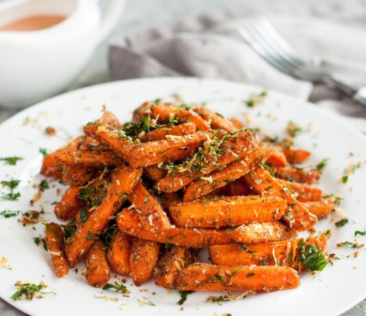 Garden Fresh- Enter by March 1 Baby carrots roasted with parmesan and herbs served with sauce on grey table